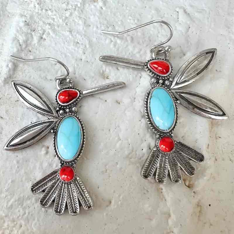 Top-down view focusing on the silver ear hook, red head stone, and detailed oxidised silver wings of the hummingbird earring.