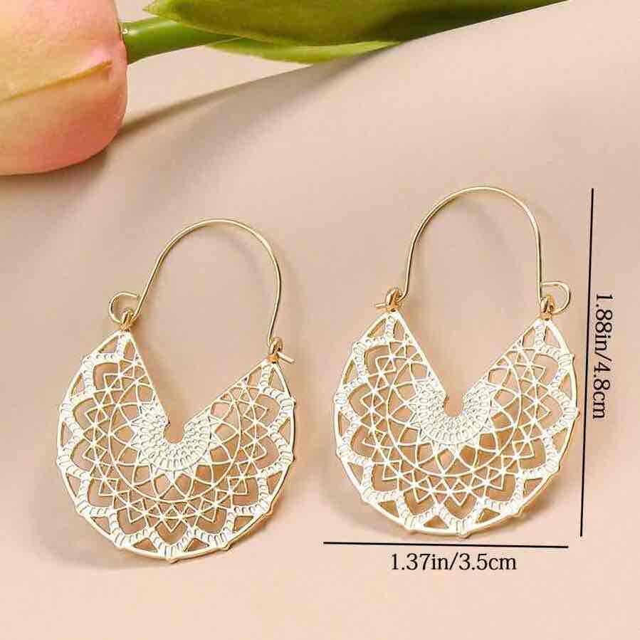 Pair of ornate gold-toned oxidised earrings with mandala pattern reflecting on white surface - wide shot | Zuzu's Trove