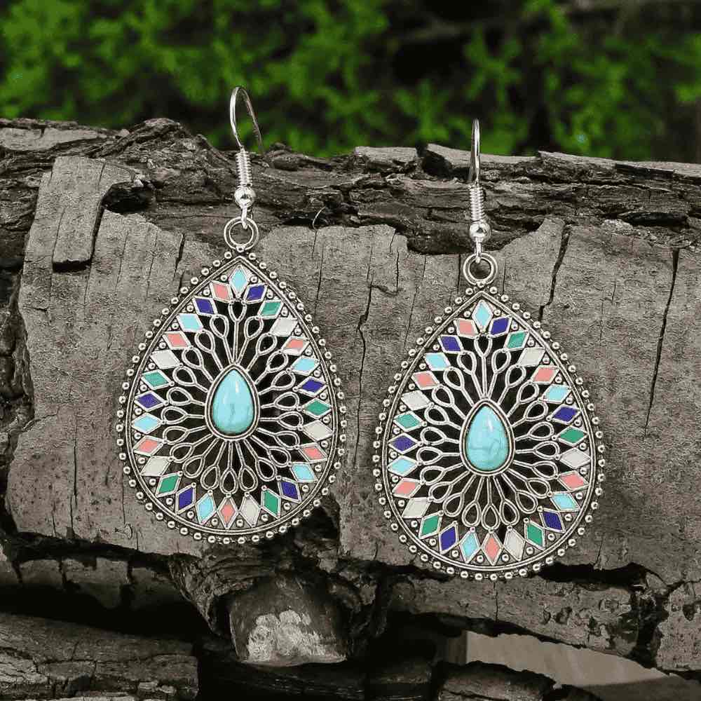 Close-up of the right silver-tone earring, showing the turquoise stone, colorful enamel, and intricate filigree detail, hangi
