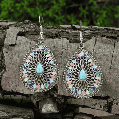 Close-up of the right silver-tone earring, showing the turquoise stone, colorful enamel, and intricate filigree detail, hangi