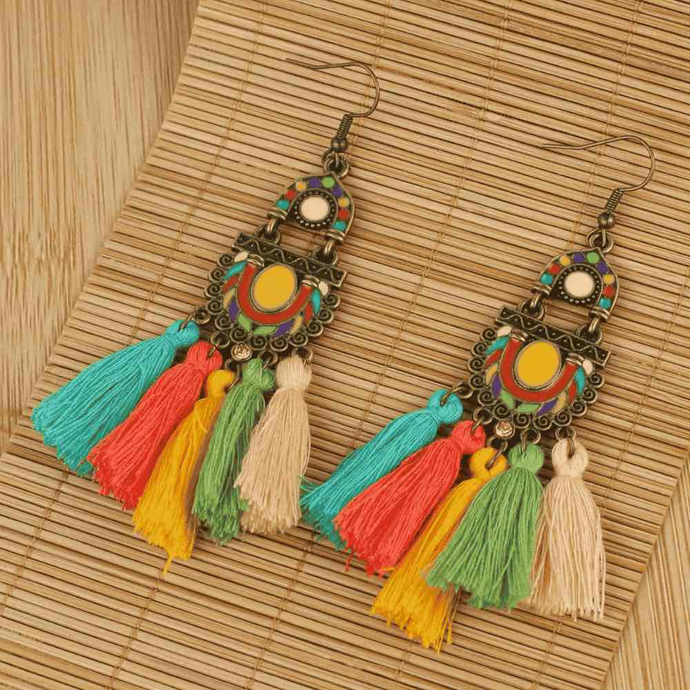 Colorful tassel earrings on a woven mat