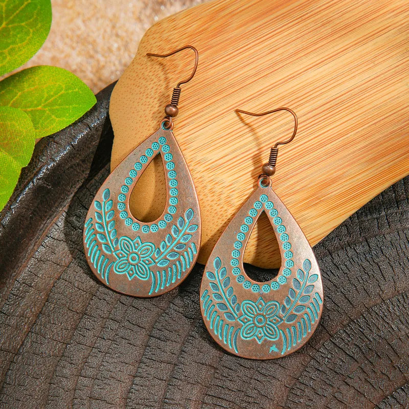 Blue oxidised teardrop dangle earrings with intricate floral and leaf patterns in teal enamel - Front view | Zuzu's Trove