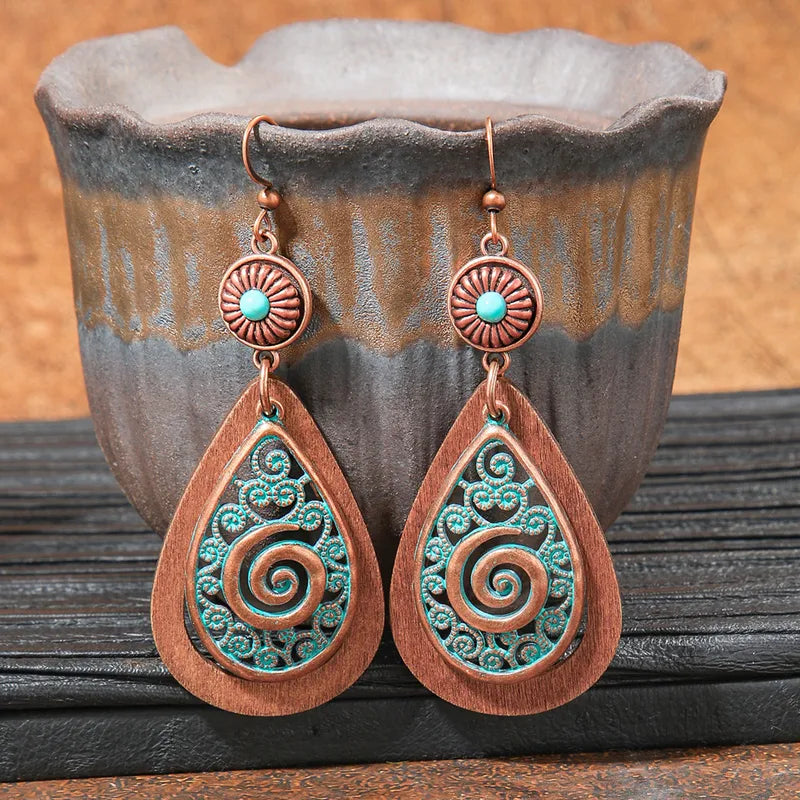 Close-up of oxidised blue teal dangle earrings showing intricate spiral design and antique finish | Zuzu's Trove