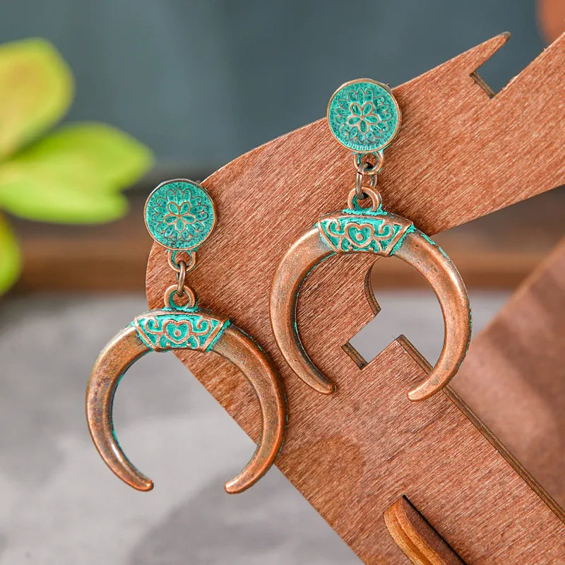 Boho oxidised crescent earrings with teal accents - Front view on wooden display | Zuzu's Trove