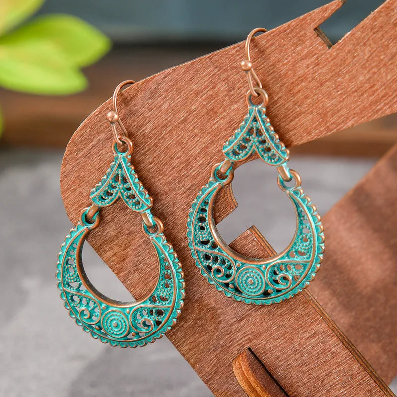 Blue oxidised dangle earrings with antique filigree design displayed on a wooden stand - full view | Zuzu's Trove