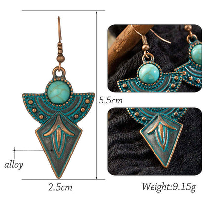 Close-up of the lower, shield-shaped part of the left antique turquoise earring, showing leaf-like patterns and oxidised fini
